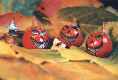 3 citrouilles méchantes sur tapis de feuilles d'automne